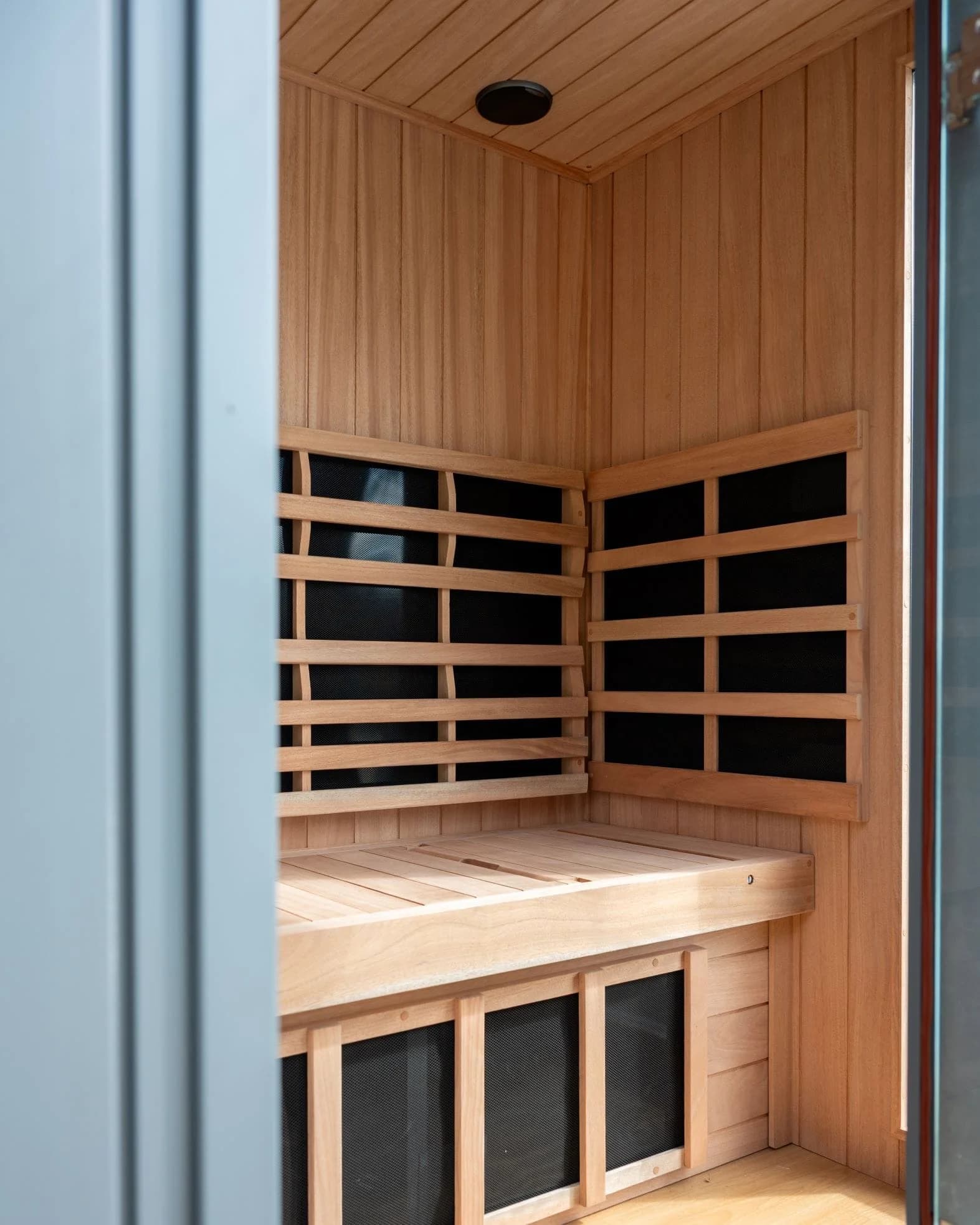 Infrared sauna interior at Soho Wellness Phuket with wooden panels and calming warm tones designed for relaxation and detox.