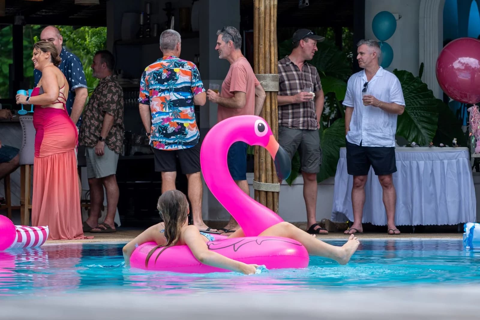 Guests enjoying a lively pool party at Soho Pool Club Phuket with drinks, music, and colorful floats