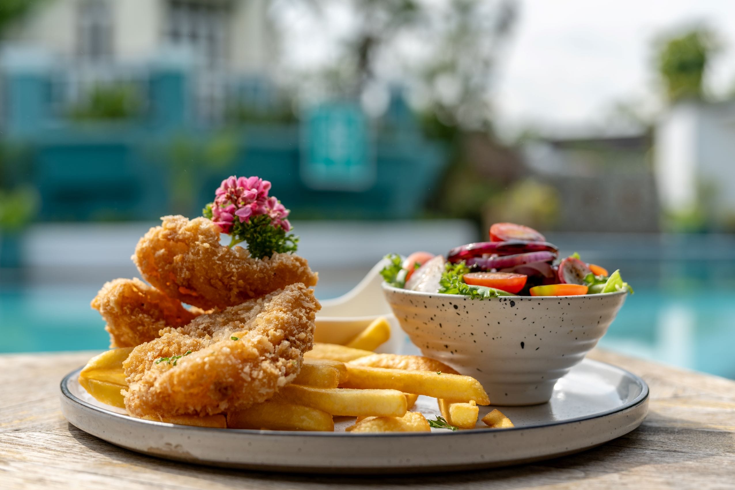Crispy golden fish and chips with fresh garden salad served poolside at SOHO Pool Club Phuket