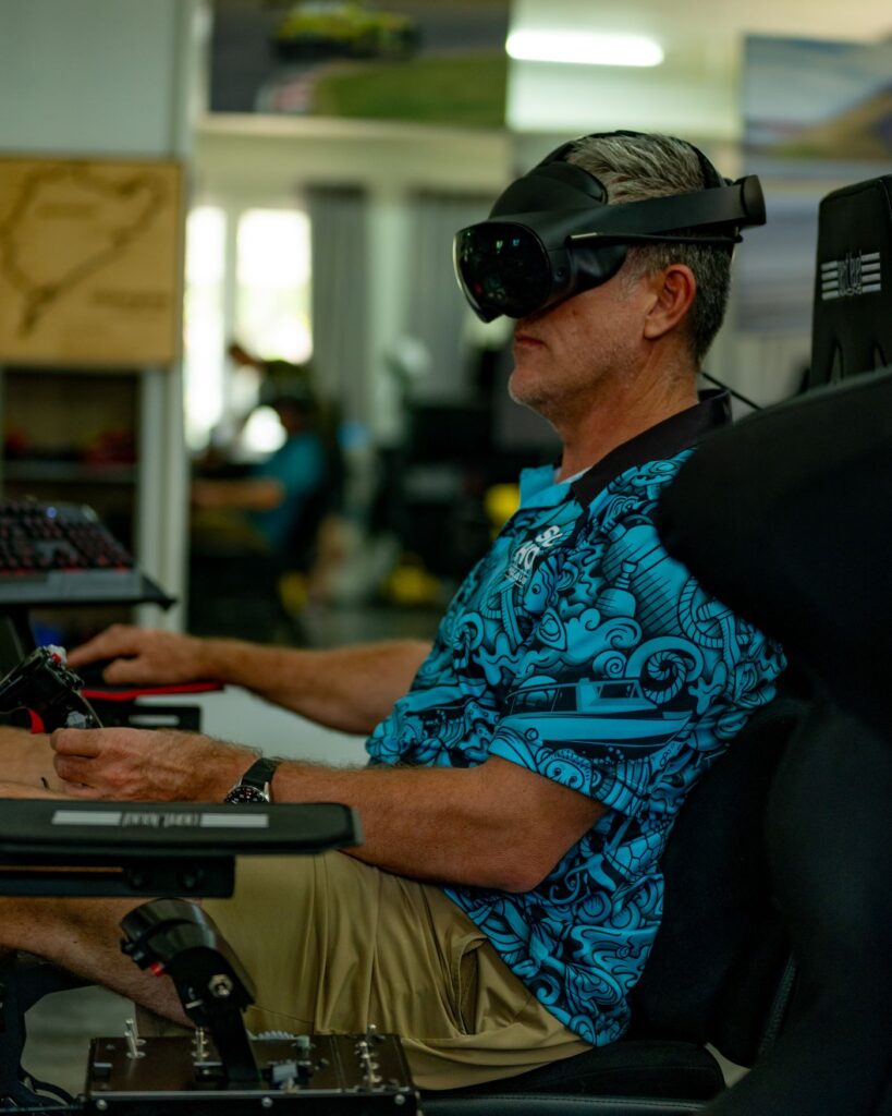 Man using VR headset inside SimPro Academy Phuket simulator room, experiencing realistic racing and flight simulation with professional controls.