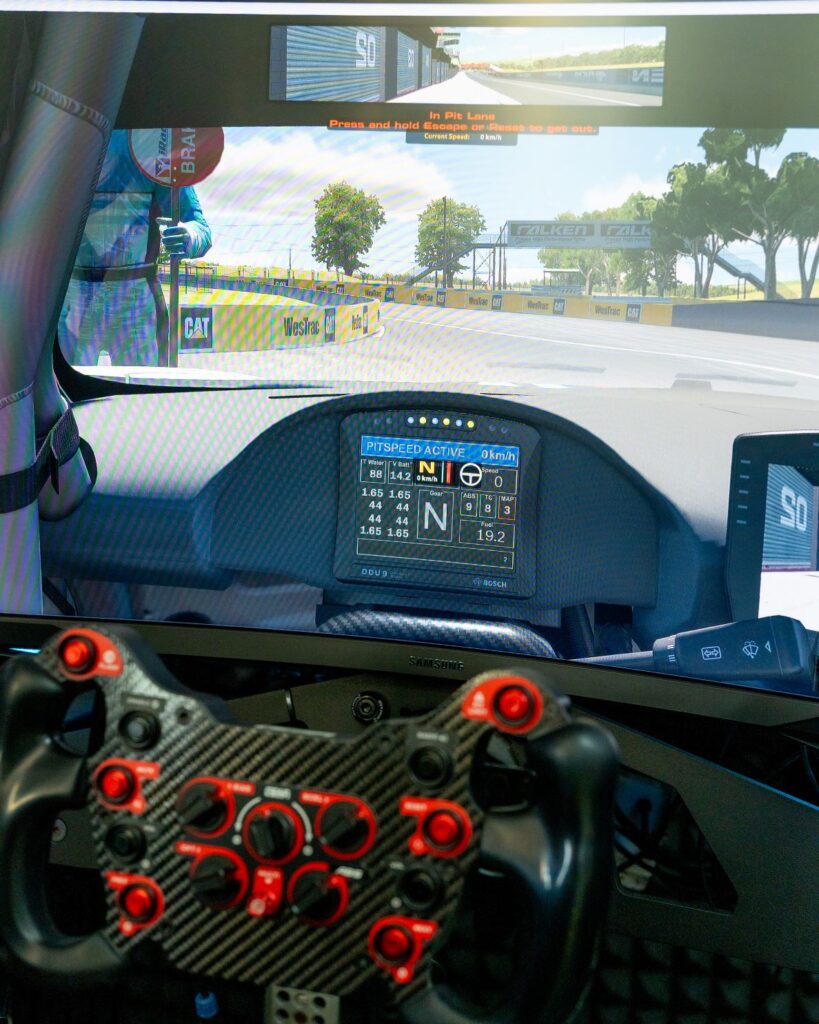 Close-up view of professional race simulator cockpit with carbon fiber steering wheel and high-definition track display at SimPro Academy Phuket.