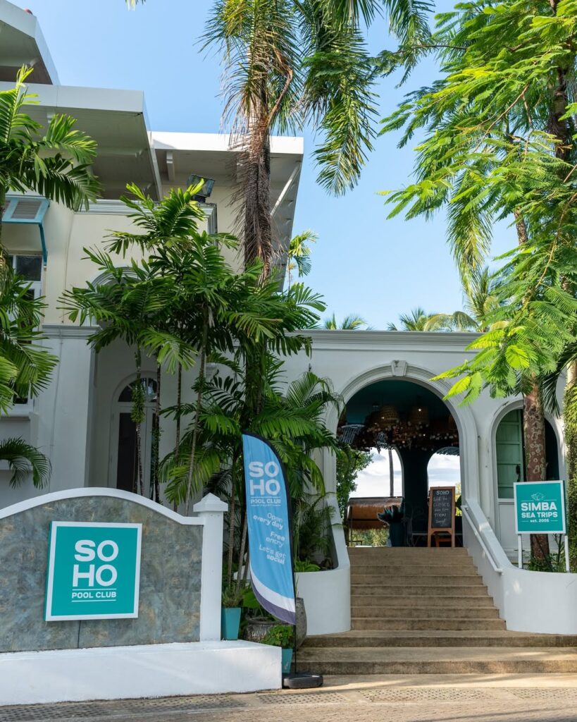 Front entrance of SOHO Pool Club surrounded by palm trees at Boat Lagoon Phuket