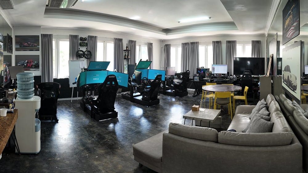 SimPro Academy Phuket interior featuring multiple professional racing simulators, equipment, and a comfortable lounge area.